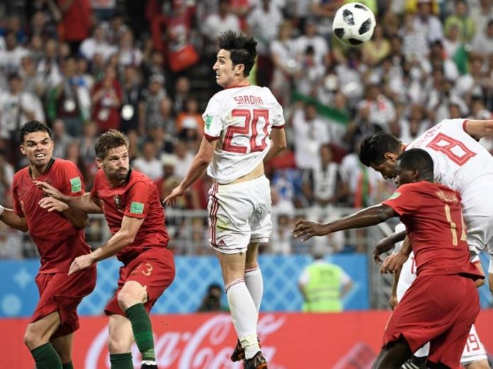 Pemain Iran berebut bola dengan pemain Portugal